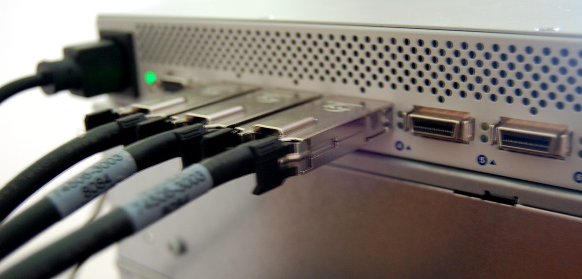 InfiniBand 스위치와 케이블 실물 사진 — 전면 QSFP 포트에 케이블이 연결된 모습